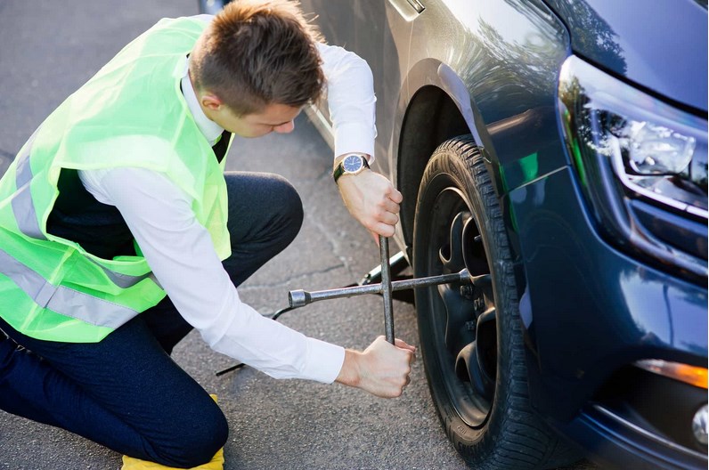 Um homem fura um pneu na estrada