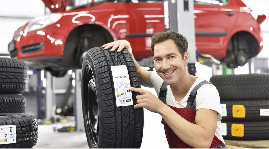 Mecânico mostra a etiqueta europeia de um pneu